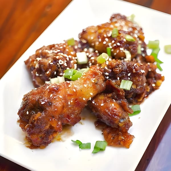 Basil & Mint's Vietnamese chicken wings, glazed with sesame seeds and chopped green onions.